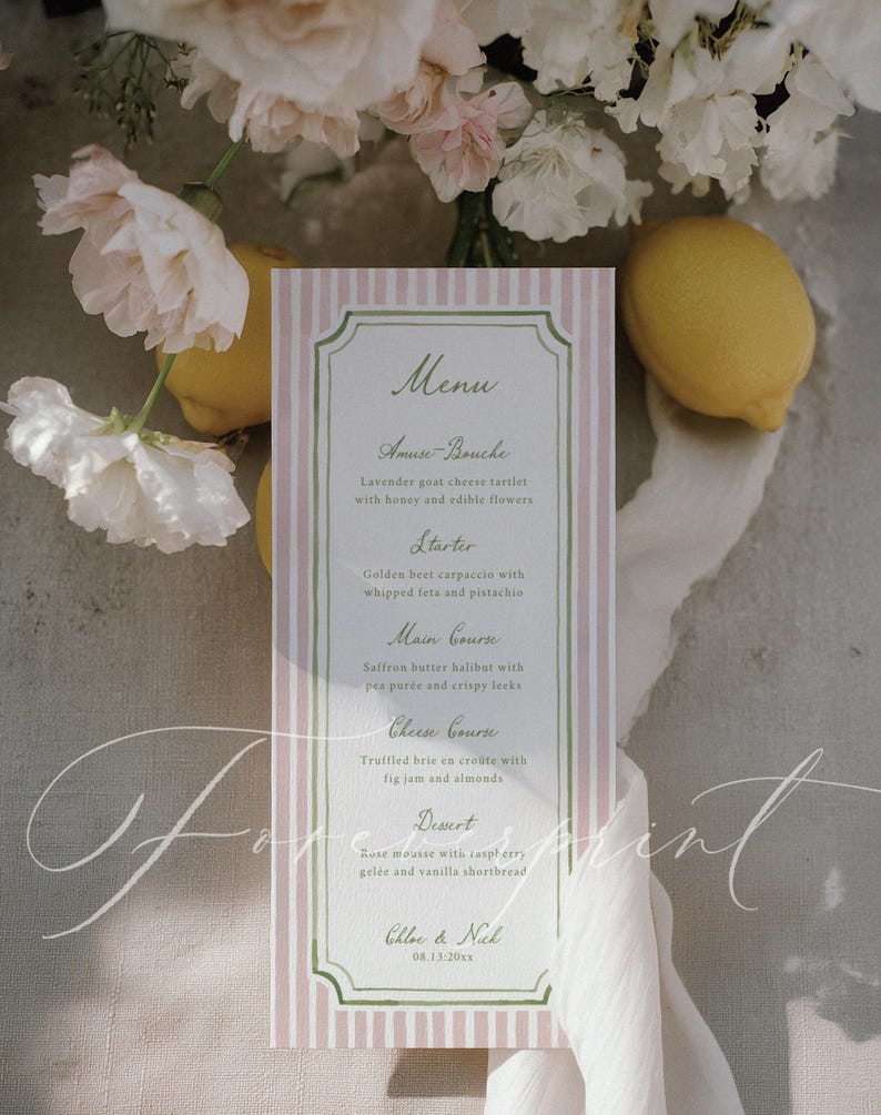 May include: A menu card with a pink and white striped background, featuring a green border and elegant script. The menu lists courses like Amuse-Bouche, Starter, Main Course, Cheese Course, and Dessert. Lemons and flowers are in the background.