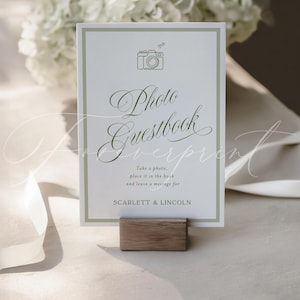 May include: A white Photo Guestbook sign with a green border and text. The sign features a camera icon and the words "Photo Guestbook". It includes the text "Take a photo, place it in the book and leave a message for Scarlett & Lincoln."