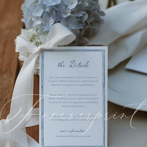 May include: A wedding details card with a blue border and text, next to a bouquet of blue and white flowers tied with a white ribbon. The card includes information about booking rooms and a phone number.