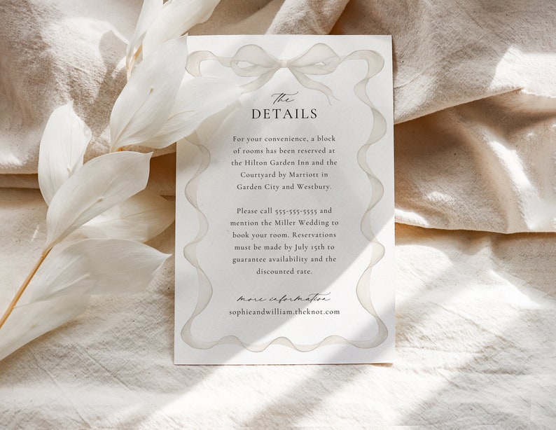 May include: A white wedding invitation with a watercolor illustration of a bow. The text reads "The Details" and includes information about hotel room blocks, contact information, and a reservation deadline.