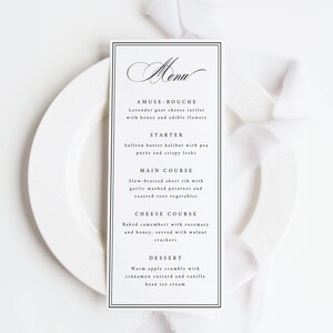 May include: A rectangular menu card with a black border and elegant script font. The menu lists courses: Amuse-bouche, Starter, Main Course, Cheese Course, and Dessert. The card is on a white plate with a white ribbon.