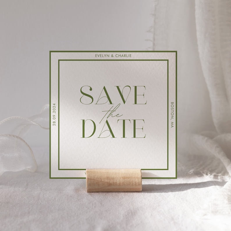 May include: A green and white save the date card with the text "Save the Date" in a modern font. The card also includes the names "Evelyn & Charlie" and the date "28.09.2024". The card is on a wooden stand and has a green border.