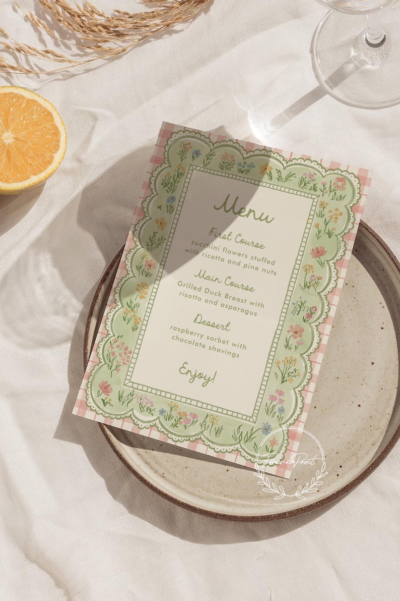 May include: A menu card with a floral border and a pink gingham background. The menu lists a first course of zucchini flowers, a main course of grilled duck breast, and a dessert of raspberry sorbet. The word "Menu" is at the top.