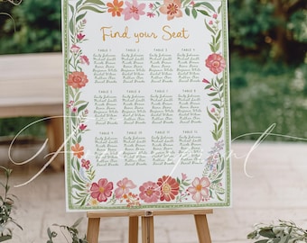 May include: A wooden easel displays a floral-decorated seating chart with the words "Find your Seat." The chart lists names under table numbers, surrounded by a border of pink, orange, and green flowers. The easel is set outdoors.