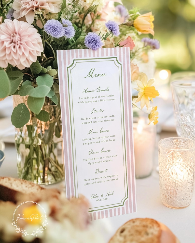 May include: A menu card with a pink and white striped background and a green border. The menu lists courses such as Amuse-Bouche, Starter, Main Course, Cheese Course, and Dessert. The menu is set on a table with flowers and candles.