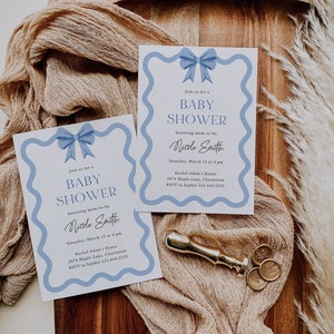 Peut inclure: Deux invitations de f&ecirc;te pr&eacute;natale bleu et blanc avec un n&oelig;ud bleu sur chacune. Les invitations ont une bordure ondul&eacute;e et le texte "Rejoignez-nous pour une f&ecirc;te pr&eacute;natale en l'honneur de la future maman Nicole Smith" avec la date, l'heure, le lieu et les informations RSVP.