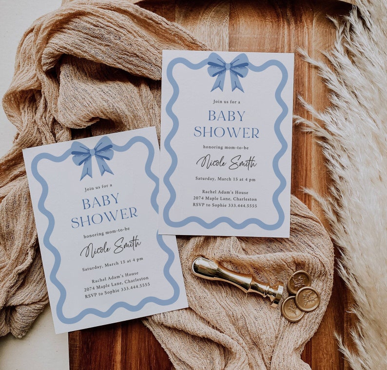 Peut inclure: Deux invitations de f&ecirc;te pr&eacute;natale bleu et blanc avec un n&oelig;ud bleu sur chacune. Les invitations ont une bordure ondul&eacute;e et le texte "Rejoignez-nous pour une f&ecirc;te pr&eacute;natale en l'honneur de la future maman Nicole Smith" avec la date, l'heure, le lieu et les informations RSVP.