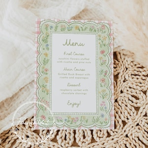 May include: A menu card with a floral design. The menu features a pink gingham background and a green border with flowers. The menu includes the text "Menu", "First Course", "Main Course", "Dessert", and "Enjoy!"