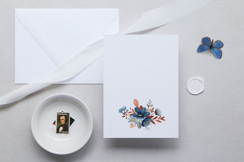 May include: A stationery set featuring a white envelope, card, and ribbon. The card is decorated with a floral design in shades of blue, orange, and gray. A small bowl holds a stamp, and a blue butterfly and wax seal are also present.