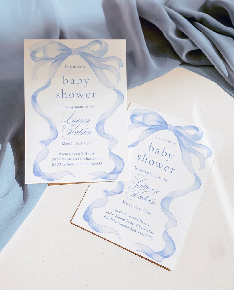 May include: Two blue and white baby shower invitations with a watercolor ribbon design. The invitations say "Join us for a baby shower honoring mom-to-be Lauren Watson" and include the date, time, location, and RSVP information.