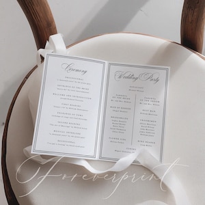 K&ouml;nnte beinhalten: Ein wei&szlig;es Hochzeitsprogramm mit schwarzem Text, das Zeremonie- und Hochzeitsgesellschaftsinformationen enth&auml;lt. Das Programm ist mit einem wei&szlig;en Band gebunden und liegt auf einer wei&szlig;en Oberfl&auml;che. Das Wort "Foreverprint" ist kursiv geschrieben.