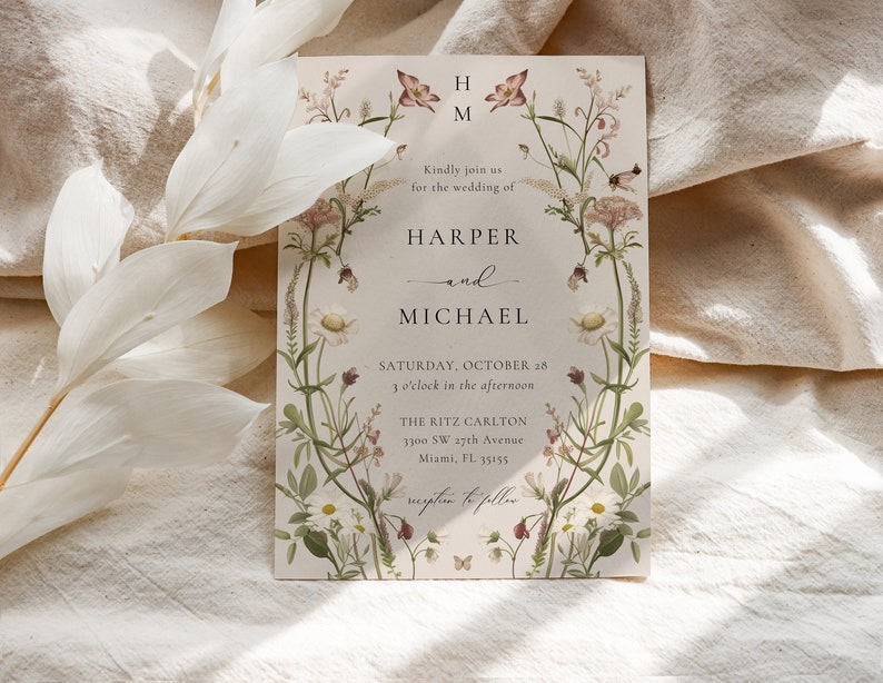 May include: Wedding invitation with floral border featuring a botanical illustration of wildflowers and butterflies. The invitation is for the wedding of Harper and Michael, taking place on Saturday, October 28th at 3 o'clock in the afternoon at The Ritz Carlton, 1300 SW 27th Avenue, Miami, FL 33155.
