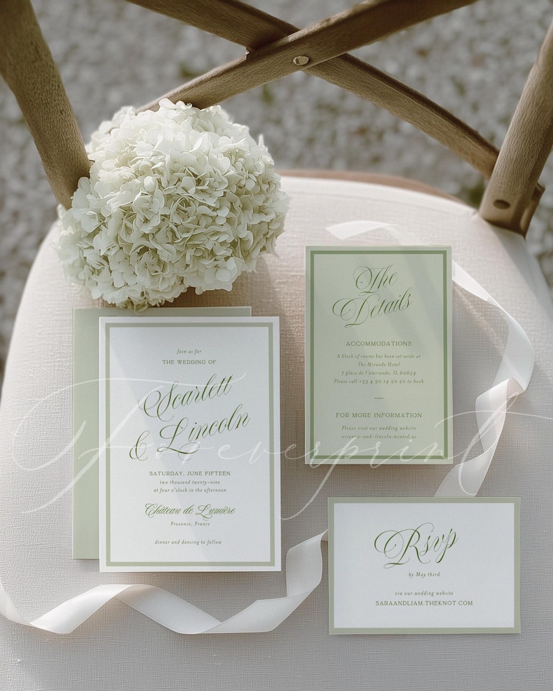 May include: Wedding stationery set with a pale green border and elegant script. The invitation reads "Scarlett & Lincoln" and includes RSVP and accommodation details. A white ribbon and a bouquet of white flowers are also present.