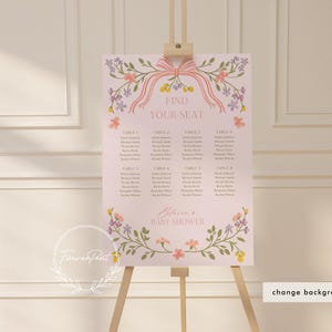 May include: A pink floral seating chart with a pink ribbon and the text "Find Your Seat" and "Baby Shower". The chart lists table numbers and guest names.