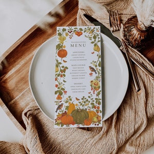 May include: A Thanksgiving menu card with a white background and a colorful autumn floral border. The menu includes appetizers, main course, and dessert options. The text reads: "Thanksgiving Menu", "Appetizers", "Shrimp Cocktail", "Caesar Salad", "Stuffed Mushrooms", "Main Course", "Filet Mignon", "Roast Chicken", "Butternut Lasagna", "Grilled Salmon", "Herbed Turkey", "Dessert", "Apple Tarte Taten", "Chocolate Cake", "Creme Brulee".