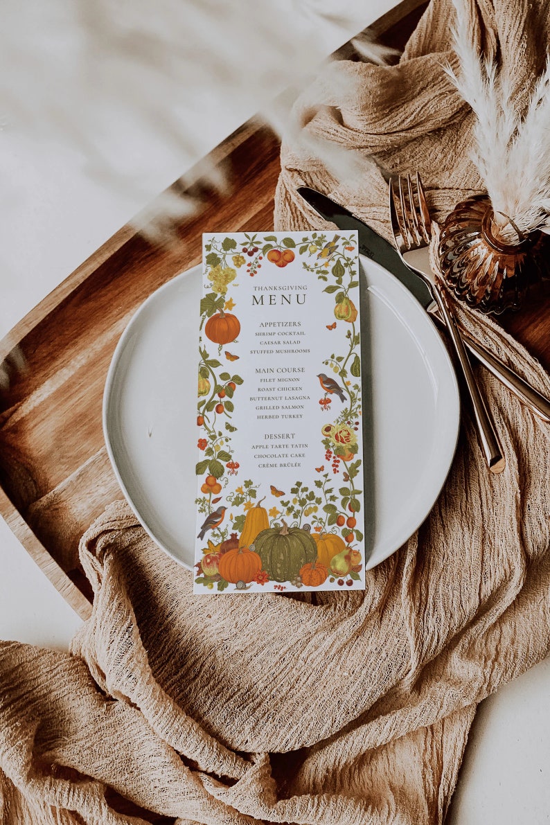 May include: A Thanksgiving menu card with a white background and a colorful autumn floral border. The menu includes appetizers, main course, and dessert options. The text reads: "Thanksgiving Menu", "Appetizers", "Shrimp Cocktail", "Caesar Salad", "Stuffed Mushrooms", "Main Course", "Filet Mignon", "Roast Chicken", "Butternut Lasagna", "Grilled Salmon", "Herbed Turkey", "Dessert", "Apple Tarte Taten", "Chocolate Cake", "Creme Brulee".