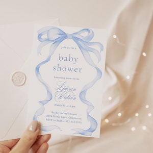 May include: A blue and white baby shower invitation with a watercolor illustration of a blue ribbon bow. The invitation reads "Join us for a baby shower honoring mom-to-be Lauren Watson, March 15 at 4 pm, Rachel Adam's House, 2074 Maple Lane, Charleston, RSVP to Sophie 333.444.5555."