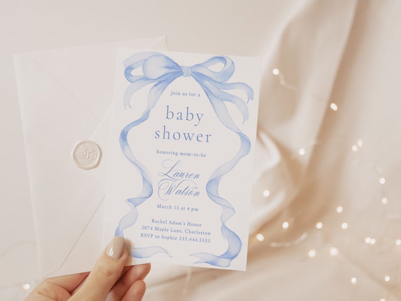 May include: A blue and white baby shower invitation with a watercolor illustration of a blue ribbon bow. The invitation reads "Join us for a baby shower honoring mom-to-be Lauren Watson, March 15 at 4 pm, Rachel Adam's House, 2074 Maple Lane, Charleston, RSVP to Sophie 333.444.5555."