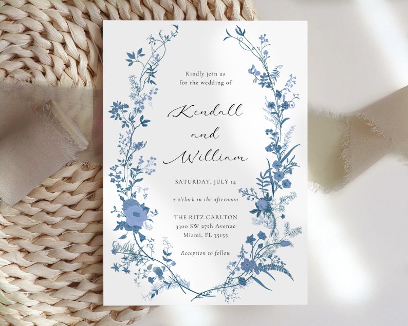May include: A wedding invitation with a blue floral design. The invitation reads "Kindly join us for the wedding of Kendall and Willinm, Saturday, July 14, 2 o'clock in the afternoon, The Ritz Carlton, 3300 SW 27th Avenue, Miami, FL 33155, Reception to follow."