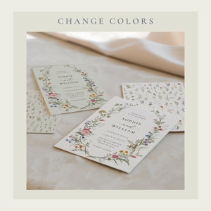 May include: Two wedding invitations with a floral wreath design. The invitations are printed on white cardstock with a light green background. The text on the invitations reads "Sophie and William".