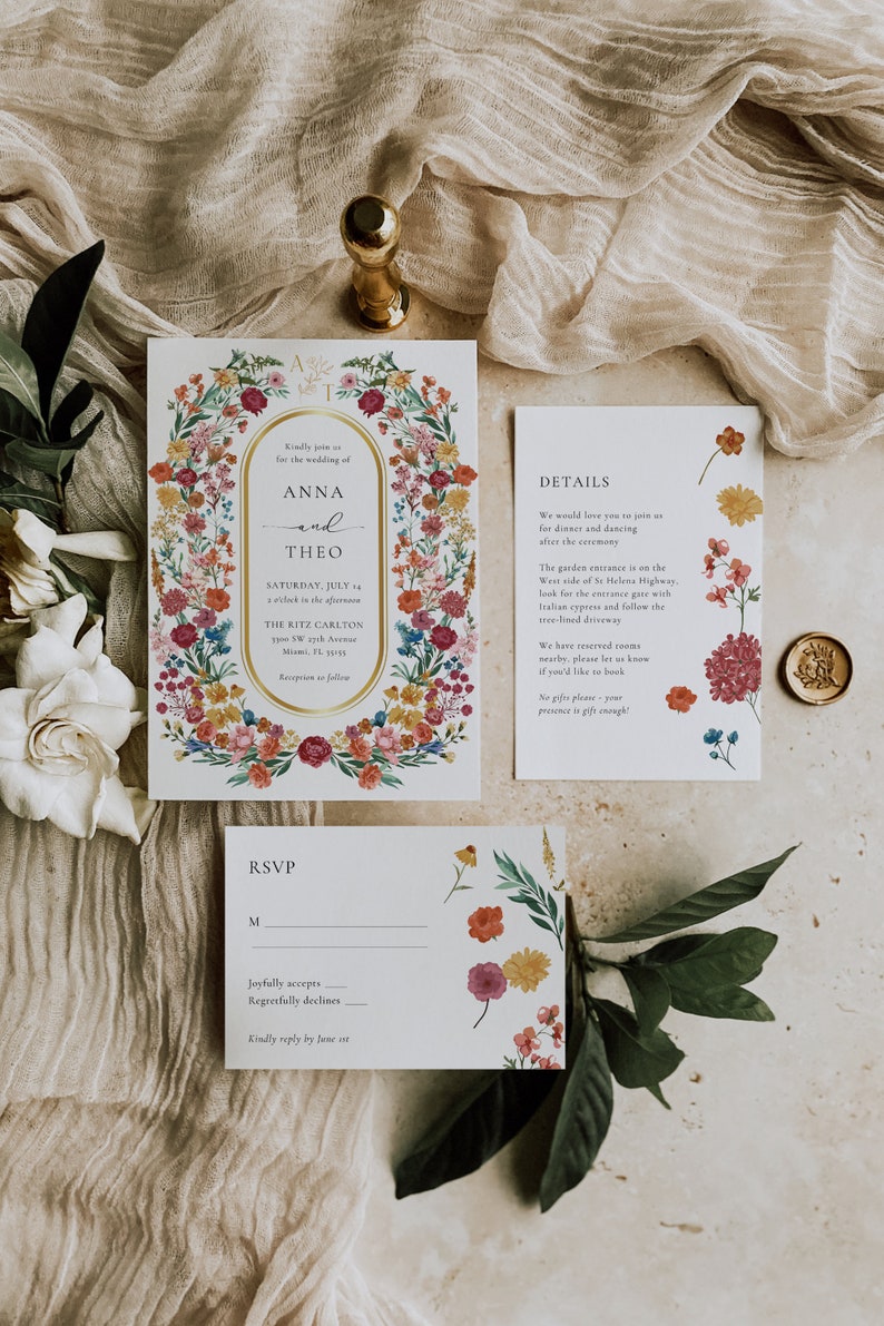 May include: A wedding invitation suite with floral designs. The invitation features a gold frame with the names Anna and Theo, the date, and the location. The RSVP card has a floral design and a space for guests to indicate their attendance.