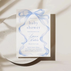 May include: A blue watercolor baby shower invitation with a large blue bow and the text "Join us for a baby shower honoring mom-to-be Lauren Watson March 15 at 4 pm Rachel Adam's House 2074 Maple Lane, Charleston RSVP to Sophie 333.444.5555"