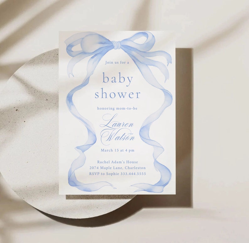 May include: A blue watercolor baby shower invitation with a large blue bow and the text "Join us for a baby shower honoring mom-to-be Lauren Watson March 15 at 4 pm Rachel Adam's House 2074 Maple Lane, Charleston RSVP to Sophie 333.444.5555"