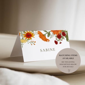 Pu&ograve; includere: Un segnaposto bianco con un design floreale con fiori arancioni, gialli e rossi. Il nome "SABINE" &egrave; stampato in testo marrone. Il testo "MATCHING ITEMS AVAILABLE" &egrave; stampato in testo marrone su un cerchio marrone chiaro. Il testo "SEE THE LISTING DESCRIPTION BELOW FOR DETAILS" &egrave; stampato in testo marrone sotto il cerchio. Un simbolo di cuore &egrave; stampato sotto il testo.