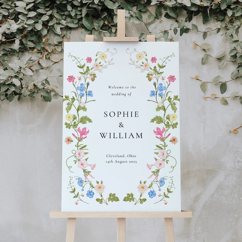 May include: A white wedding welcome sign with a floral border. The sign reads "Welcome to the wedding of Sophie & William, Cleveland, Ohio, 14th August 2023".