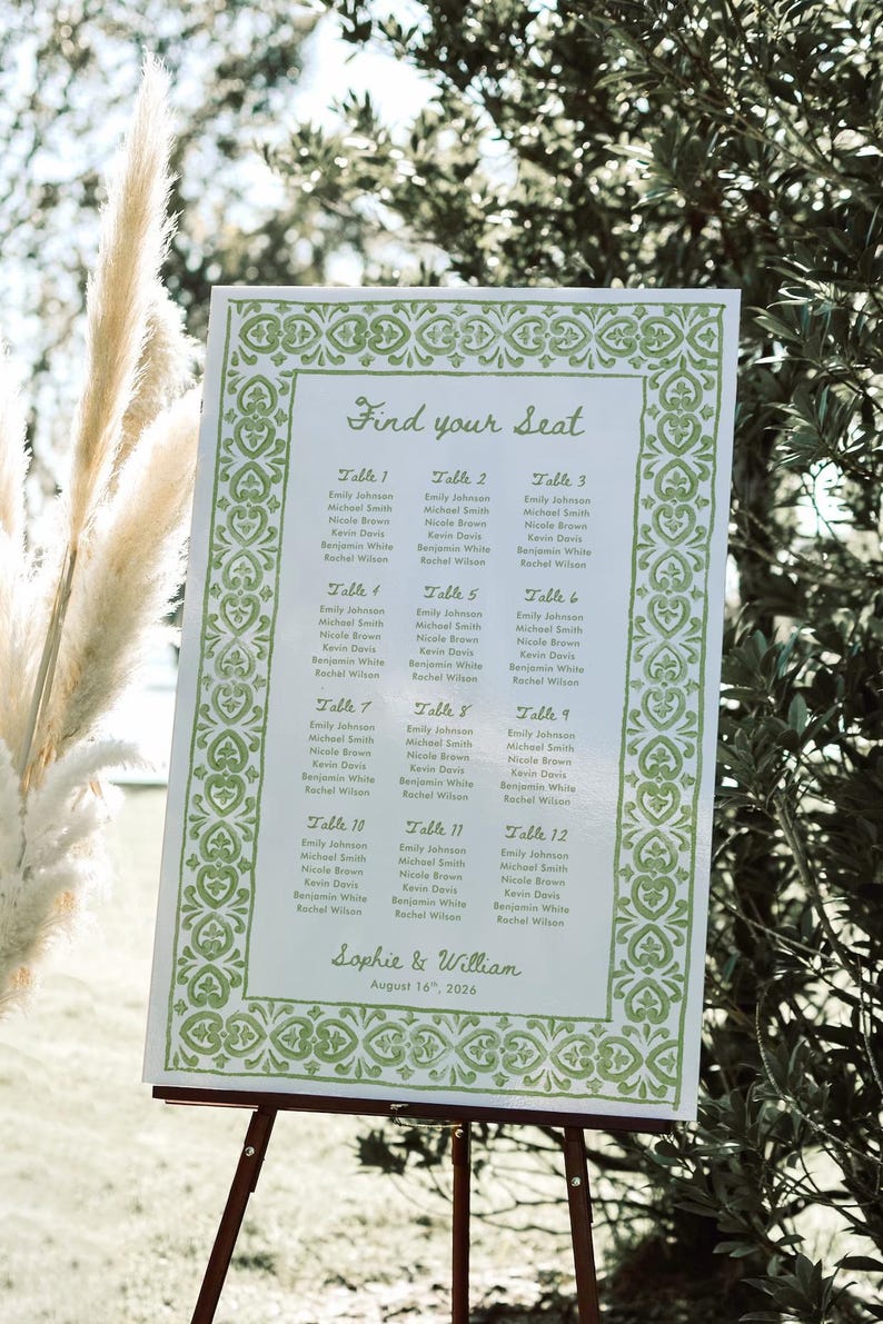 May include: A white wedding seating chart with green decorative borders and text. The sign reads "Find your Seat" and lists guest names under table numbers. The event is for Sophie & William, August 16th, 2026.