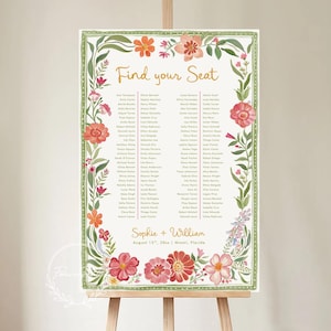 May include: A floral wedding seating chart on an easel. The chart features the words "Find your Seat" in gold script, surrounded by a green border with colorful flowers. The names of the guests are listed below. The names of the bride and groom are also listed.
