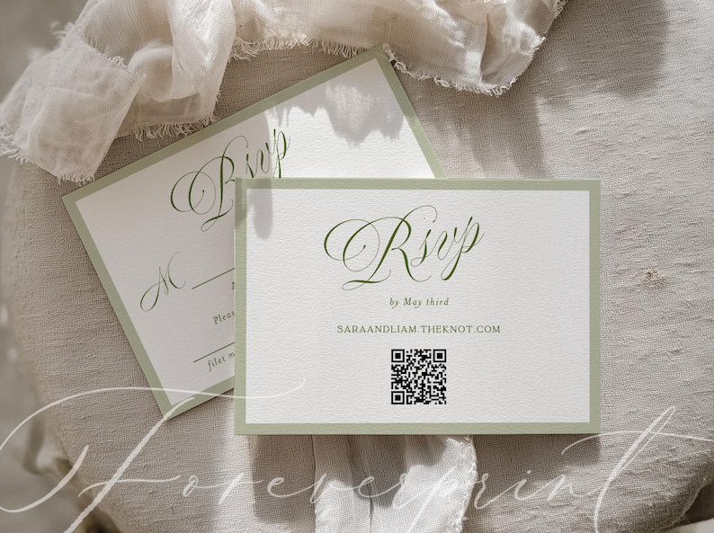 May include: Two white RSVP cards with a sage green border and elegant script. The cards include the text "RSVP by May third" and a QR code. The background is a neutral linen fabric.