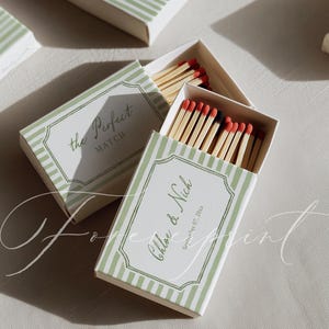 May include: Matchboxes with green and white striped design. One box is open, revealing wooden matches with red tips. The text "Chloe & Nick September 07, 20xx" is printed on the box. Another box reads "the Perfect MATCH".