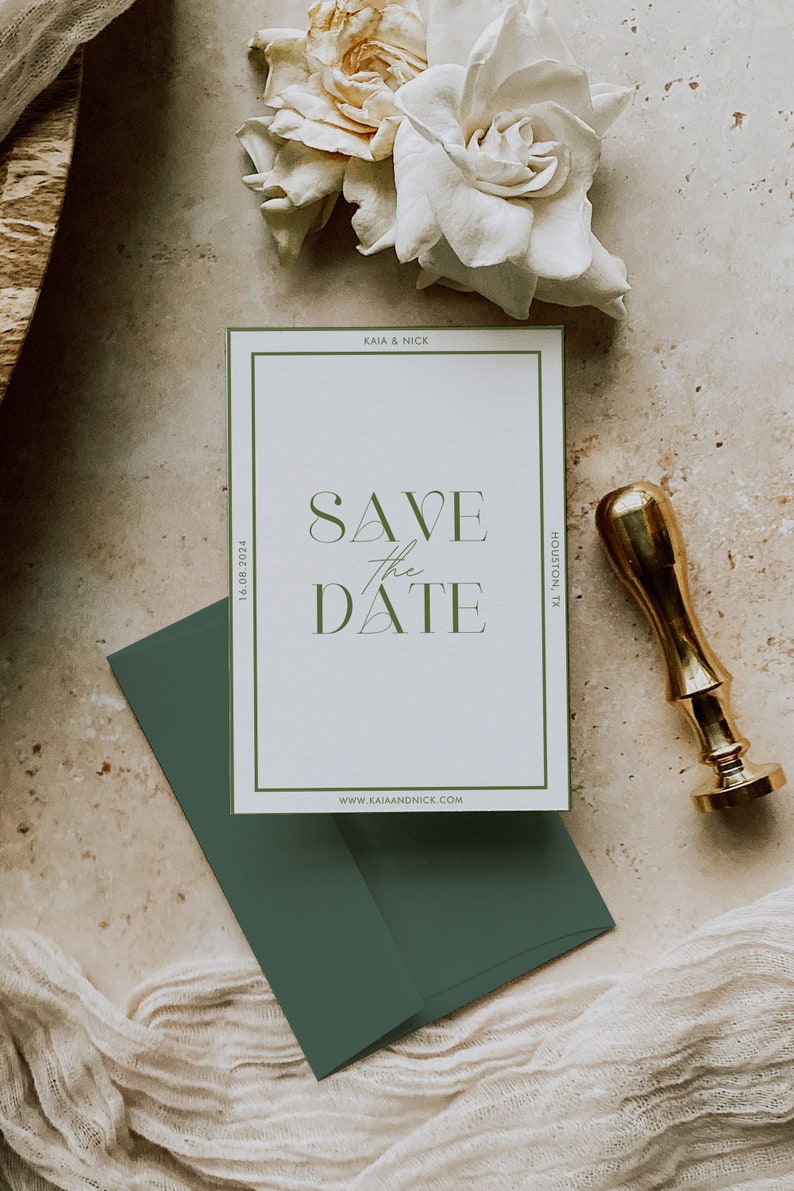 May include: A wedding invitation suite featuring a white card with green text that reads "SAVE the DATE". The card is in a green border, with a matching green envelope. A gold wax seal and white flowers are also present.