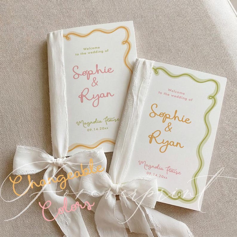 May include: Two white wedding programmes featuring wavy borders in yellow and green. The text reads Welcome to the wedding of Sophie & Ryan, Magnolia House, 09.14.20xx. Each programme is bound with a white frayed-edge ribbon tied into a bow at the base.