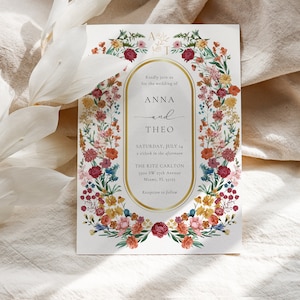 May include: A wedding invitation with a floral border in shades of pink, red, orange, yellow, and blue. The invitation reads "Kindly join us for the wedding of Anna and Theo, Saturday, July 14, 2 o'clock in the afternoon, The Ritz Carlton, 1100 SW 27th Avenue, Miami, FL 33155, Reception to follow."