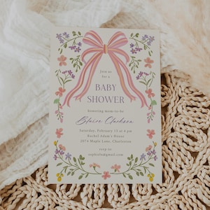 Op de afbeelding: Een baby shower uitnodiging met een roze en gele strik en bloemmotieven. De uitnodiging luidt: "Doe mee met een baby shower ter ere van de aanstaande moeder Blaise Clarkson. Zaterdag 15 februari om 16:00 uur Rachel Adam's House 2074 Maple Lane, Charleston RSVP naar: sophielu@gmail.com"
