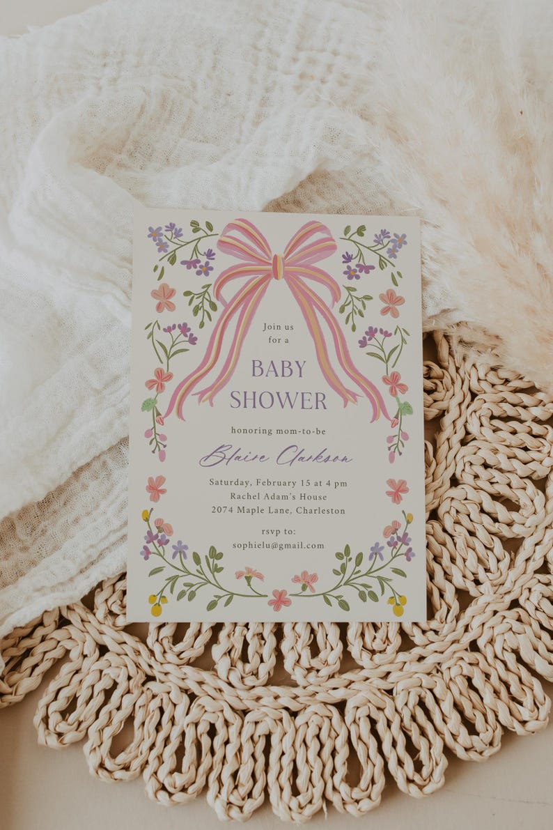 Op de afbeelding: Een baby shower uitnodiging met een roze en gele strik en bloemmotieven. De uitnodiging luidt: "Doe mee met een baby shower ter ere van de aanstaande moeder Blaise Clarkson. Zaterdag 15 februari om 16:00 uur Rachel Adam's House 2074 Maple Lane, Charleston RSVP naar: sophielu@gmail.com"