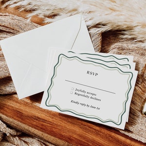 May include: A white RSVP card with a green and white border. The card has two checkboxes with the text "Joyfully accepts" and "Regretfully declines". The card also includes the text "Kindly reply by June 1st".