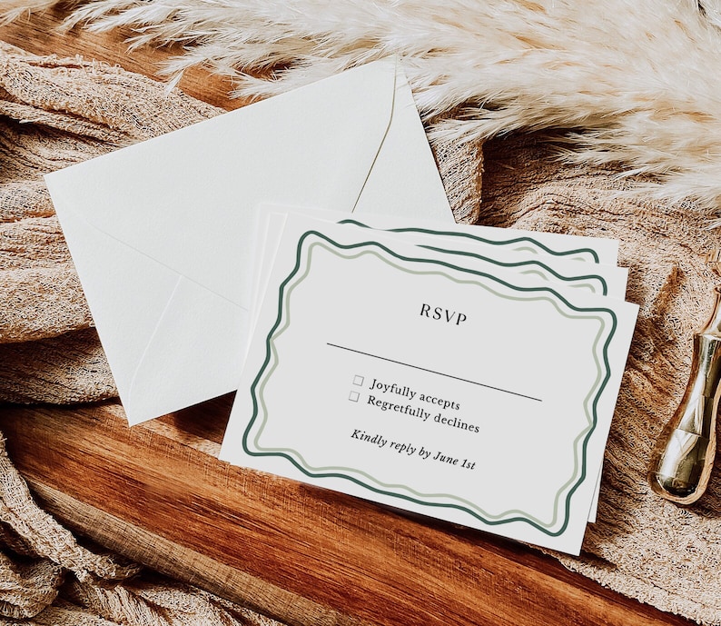May include: A white RSVP card with a green and white border. The card has two checkboxes with the text "Joyfully accepts" and "Regretfully declines". The card also includes the text "Kindly reply by June 1st".