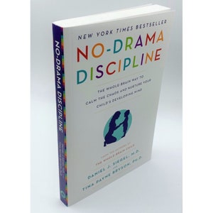 May include: A hardback book titled "NO-DRAMA DISCIPLINE" with a colourful cover. The spine displays the title vertically. The cover includes the subtitle: "THE WHOLE-BRAIN WAY TO CALM THE CHAOS AND NURTURE YOUR CHILD'S DEVELOPING MIND."