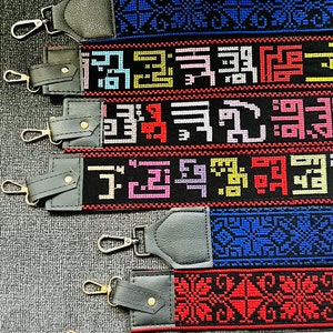 Peut inclure: Un ensemble de huit sangles tiss&eacute;es color&eacute;es avec des extr&eacute;mit&eacute;s en cuir noir. Les sangles pr&eacute;sentent diff&eacute;rents motifs g&eacute;om&eacute;triques et designs dans diverses couleurs, notamment le rouge, le bleu, le jaune et le vert.