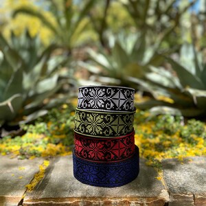 Peut inclure: Cinq bandes tiss&eacute;es noires et blanches avec des motifs g&eacute;om&eacute;triques empil&eacute;es sur une surface en pierre avec un fond vert.