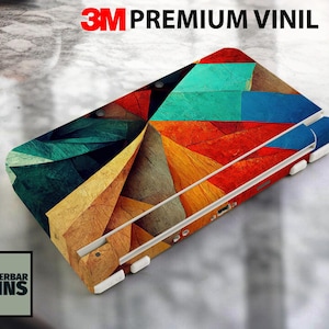 Puede incluir: Una colorida funda para dispositivo, con un diseño geométrico en tonos rojos, azules, verdes y amarillos. La funda lleva la etiqueta "3M PREMIUM VINIL" y el logotipo "WUNDERBAR SKINS". La funda está diseñada para proteger y personalizar el dispositivo.