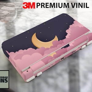 May include: A pink and blue Nintendo 3DS XL console skin with a crescent moon and clouds design. The skin is made of 3M premium vinyl.