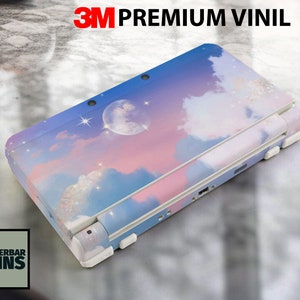 May include: A pink, blue, and white Nintendo 3DS XL console skin with a cloud and moon design. The skin is made of 3M premium vinyl.
