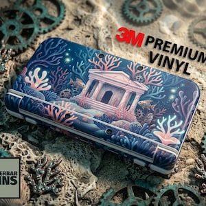 Könnte beinhalten: Eine blaue und weiße elektronische Gerätehülle mit einer Unterwasserszene mit Korallen, Fischen und einem Tempel. Die Hülle ist mit "3M Premium Vinyl" beschriftet und trägt den Text "Wunderbar Skins".