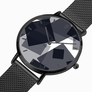 Puede incluir: Reloj de pulsera negro con un diseño geométrico en la esfera. La esfera presenta un patrón de formas grises y negras superpuestas. El reloj tiene una correa de malla negra y una caja negra. Las letras "OB" son visibles en la esfera.