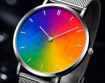 May include: A wristwatch with a silver-toned metal mesh band and a round silver case. The watch face features a vibrant, smooth gradient transitioning through rainbow colors, including blue, green, yellow, and orange, with thin silver hour markers.