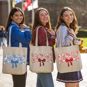 Three young women standing together, each carrying a tote bag with a red ribbon and the word "Wildcats" printed on it.